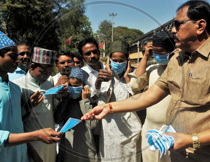 Protective masks are distributed outside a railway station in Mumbai, India on March 14, 2020.