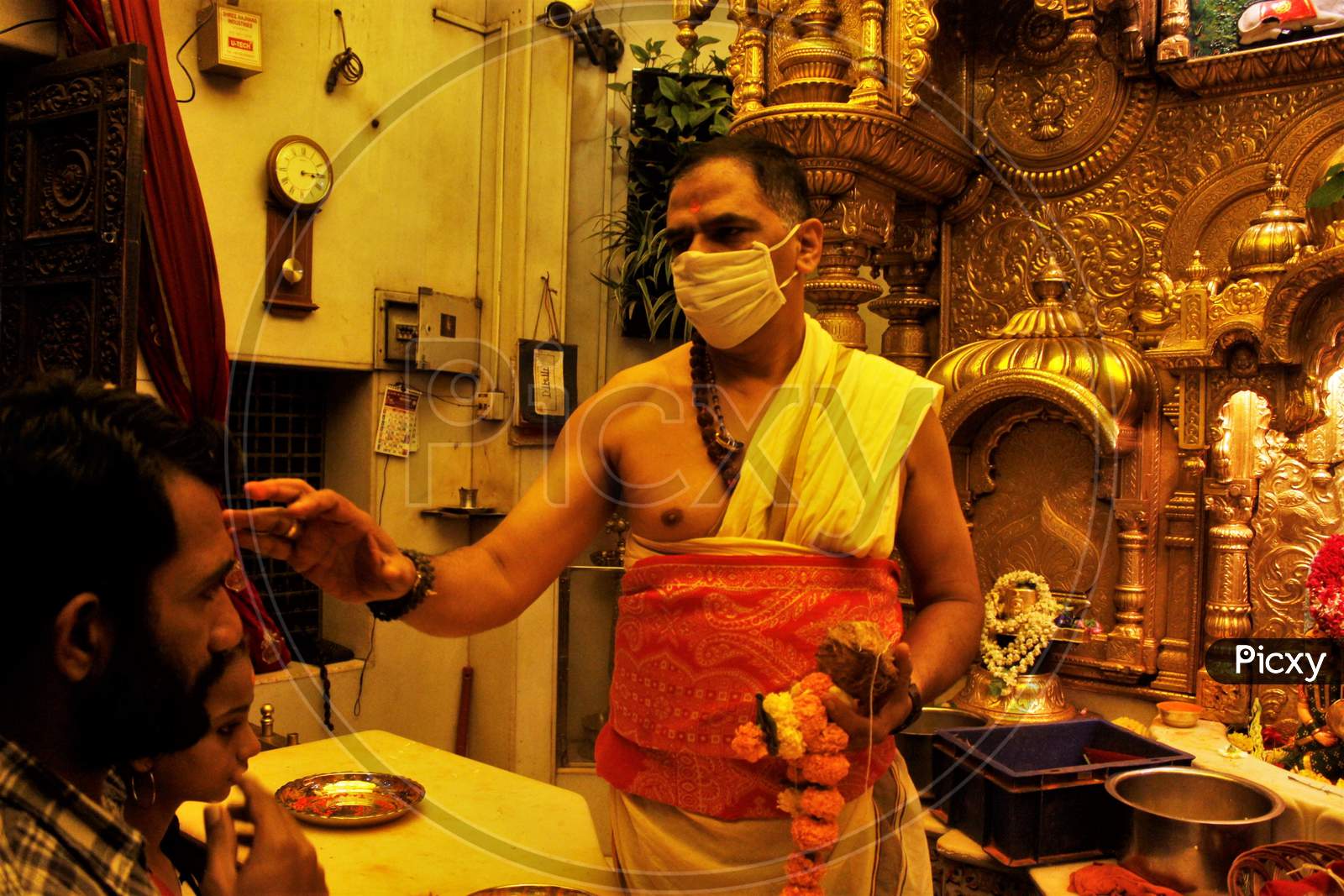 A Hindu priest wearing a protective mask is seen inside a temple in Mumbai, India, March 13, 2020.