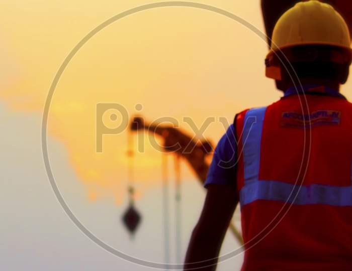 Dhaka,Bangladesh-January 17,2020 : Image Of A Construction Worker With Yellow Helmet On Construction Site During Sun Set.