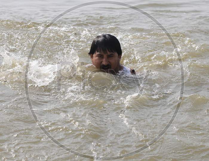 A Man  Taking Holy Bath In Triveni Sangam River on a Hot Summer Day During Extended Nationwide Lockdown Amidst Coronavirus Or COVID-19 Pandemic in Prayagraj, May 24,2020