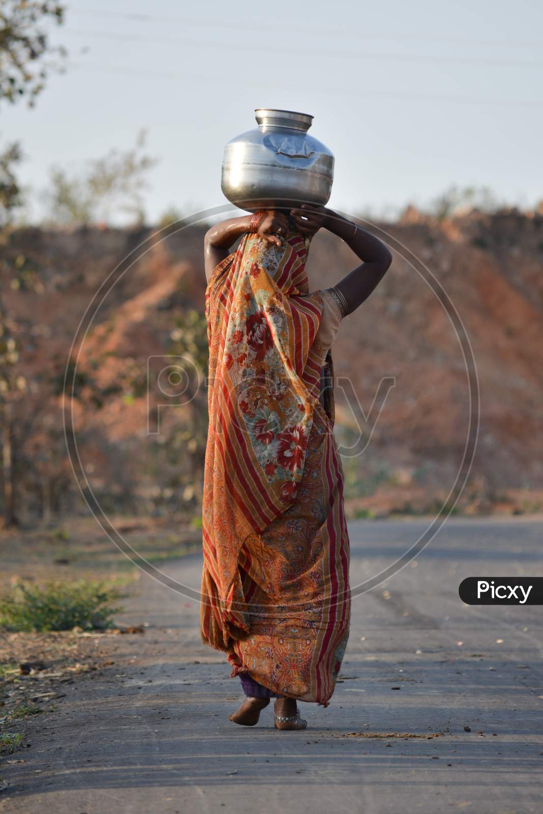 An Indian woman carrying a container of water on her head