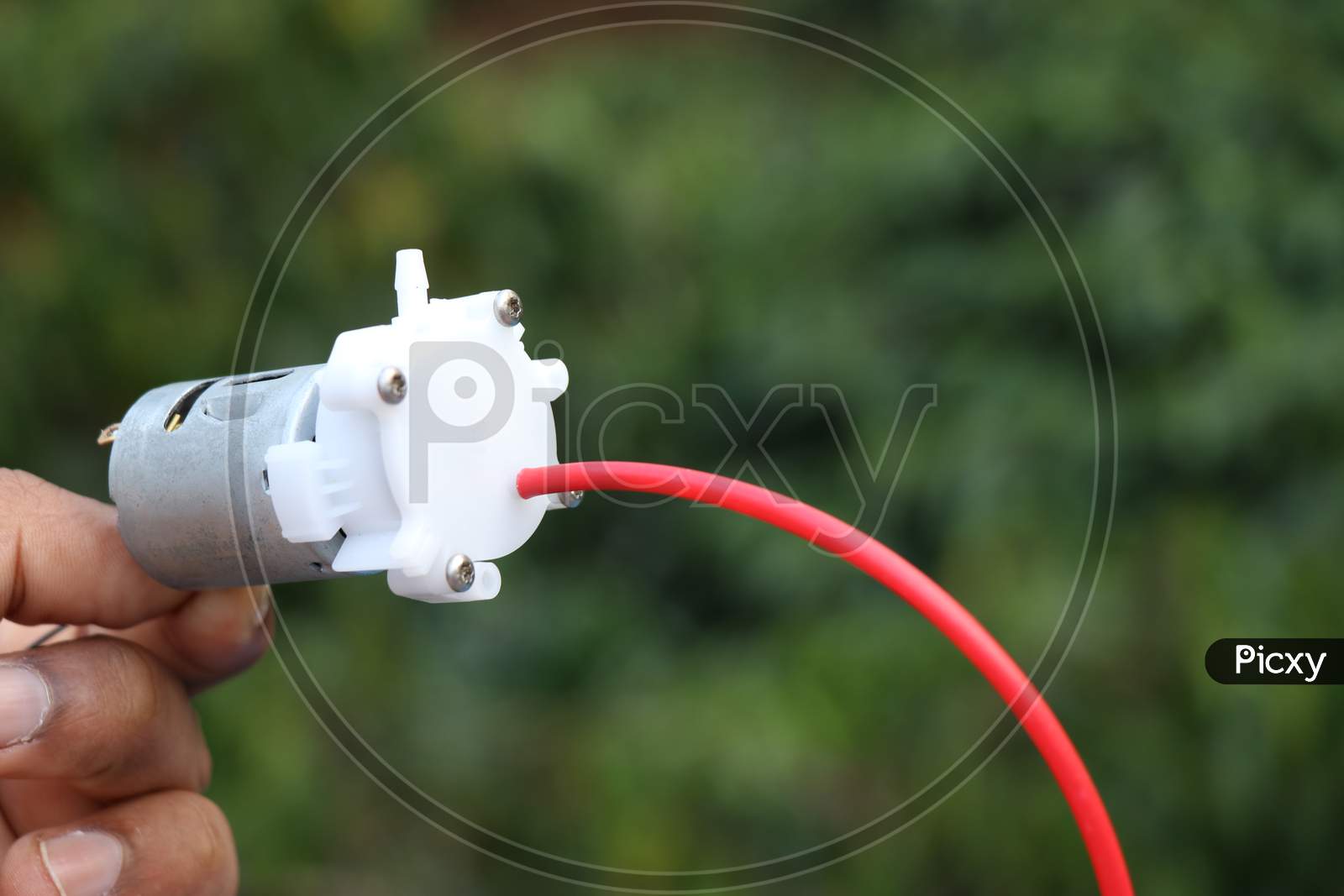 Small Dc Motor Powered Water Pump With Small Tubes Held In Hand