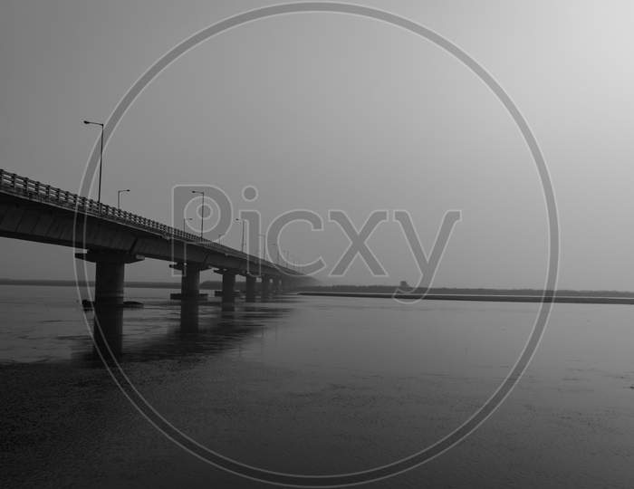 Road Bridge Over River With Its Water Reflection At Dawn From Low Angle Black And White