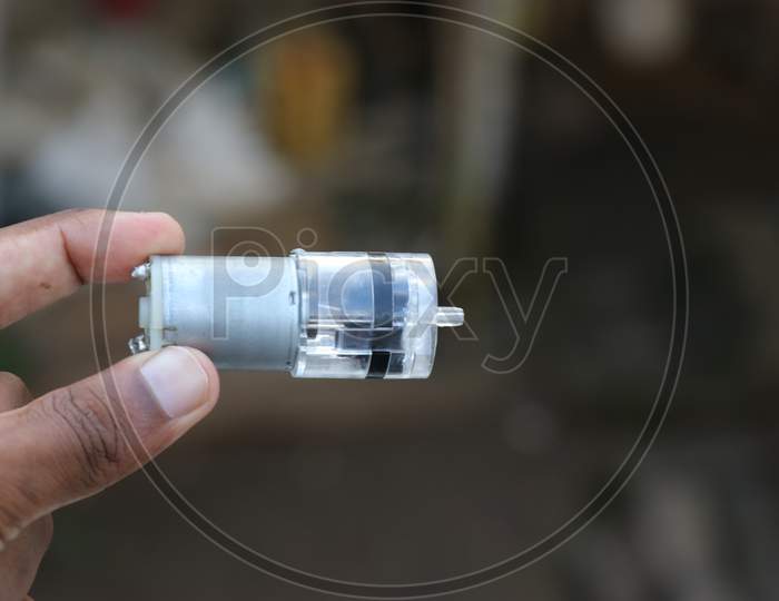 Dc Motor With Mini Air Pump Connected Held In Hand