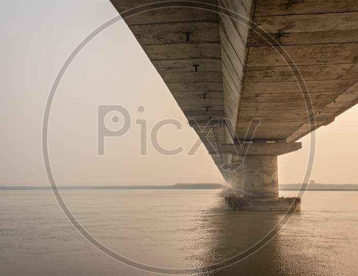 Road Bridge Over River With Its Water Reflection At Dawn From Low Angle