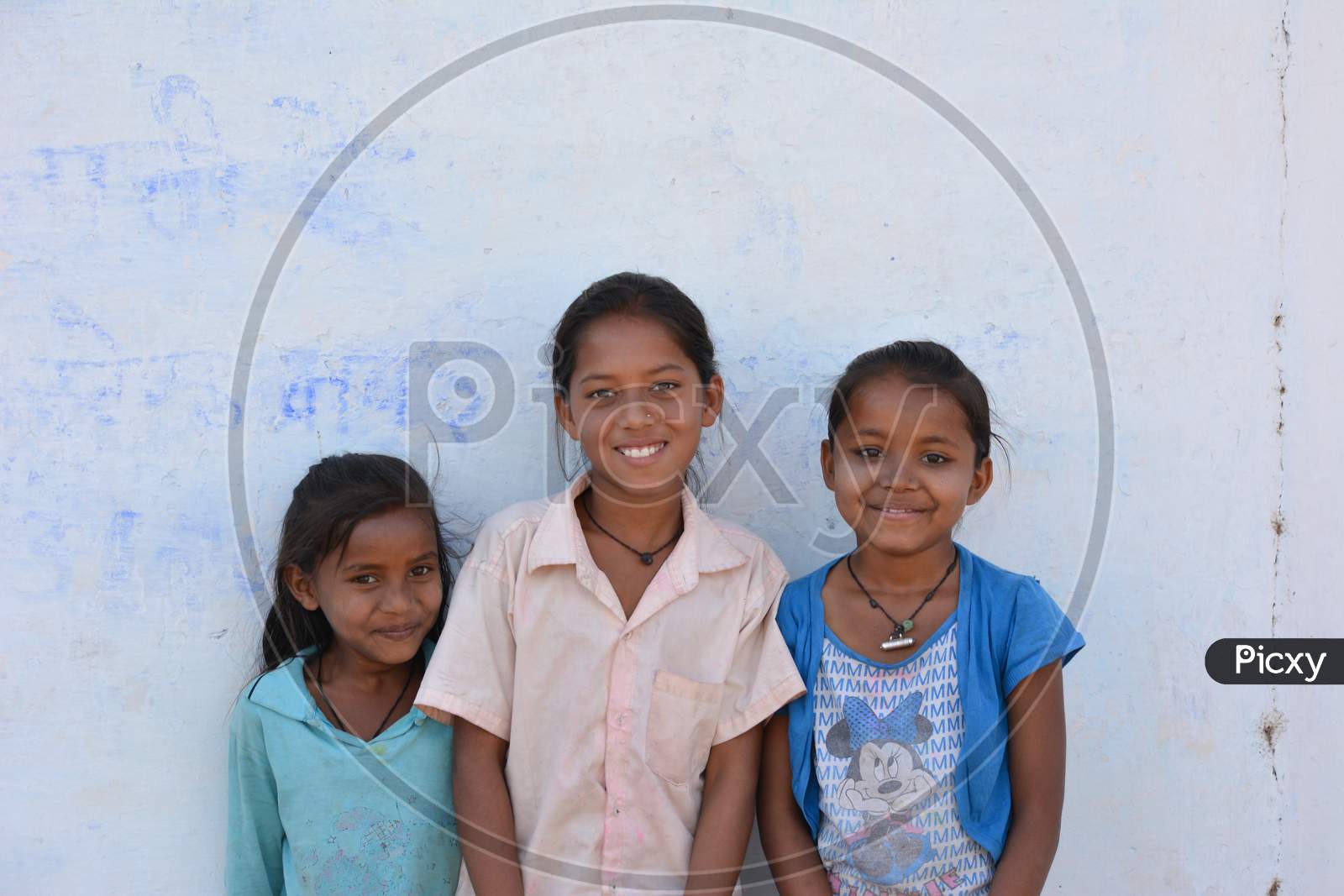 TIKAMGARH, MADHYA PRADESH, INDIA - MARCH 24, 2020: Group of happy Indian little village girls standing in front of their house.