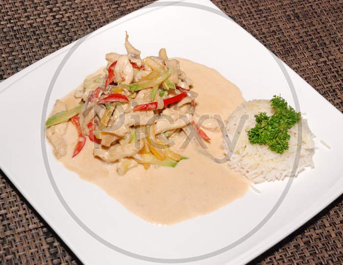 Rice With Chicken In Sauce On The White Plate