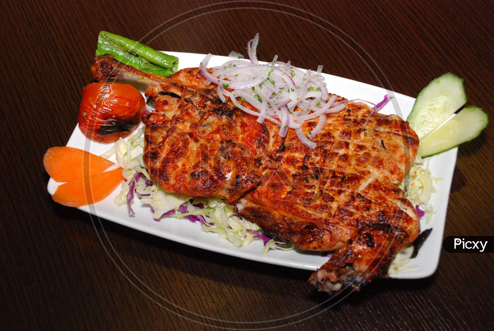 Grilled Half A Chicken On The Plate With Onion And Vegetables