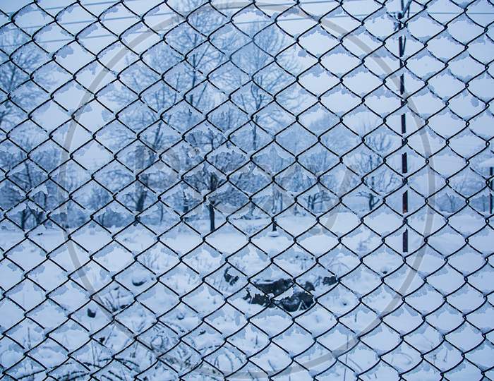 Wire Fence In The Snow. Fence Background. Metallic Net With Snow. Metal Net In Winter Covered With Snow. Wire Fence Closeup. Steel Wire Mesh Fence Vintage Effect. - Image