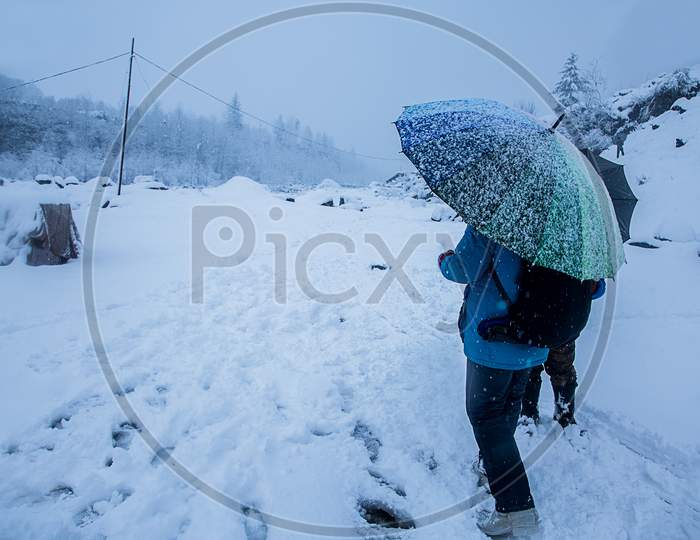 People With Umbrella Walking At Heavy Snowy Day In The Himachal. Snowfall Winter Concept, Wide Angle Shot - Image