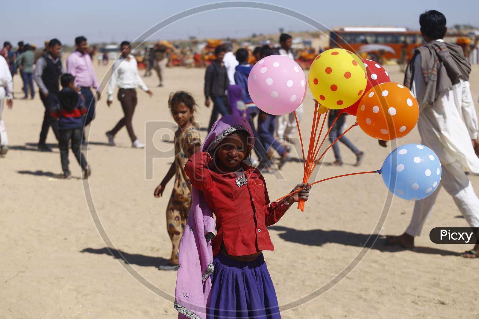 An Indian Girl Child Selling Balloons in Jaisalmer Desert Festival, Rajasthan, India