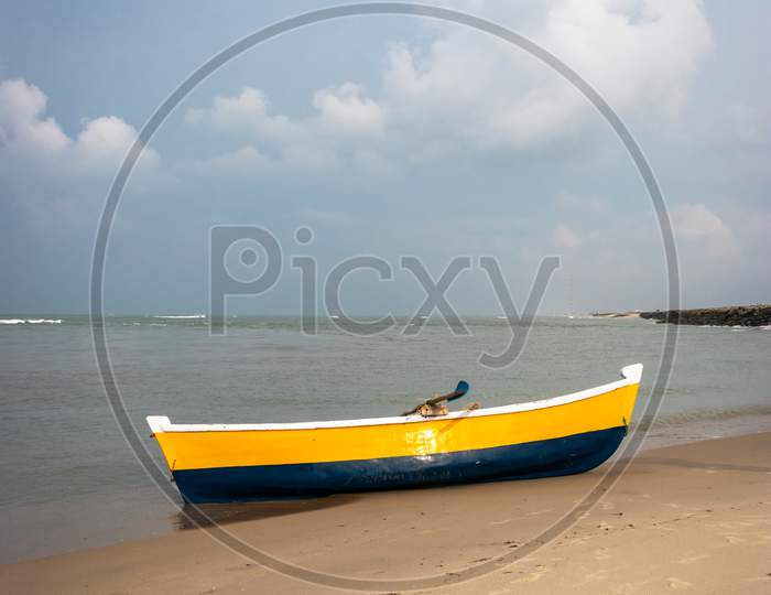 Fishing Boat On The Yellow Sandy Beach With Clouds And Blue Sky