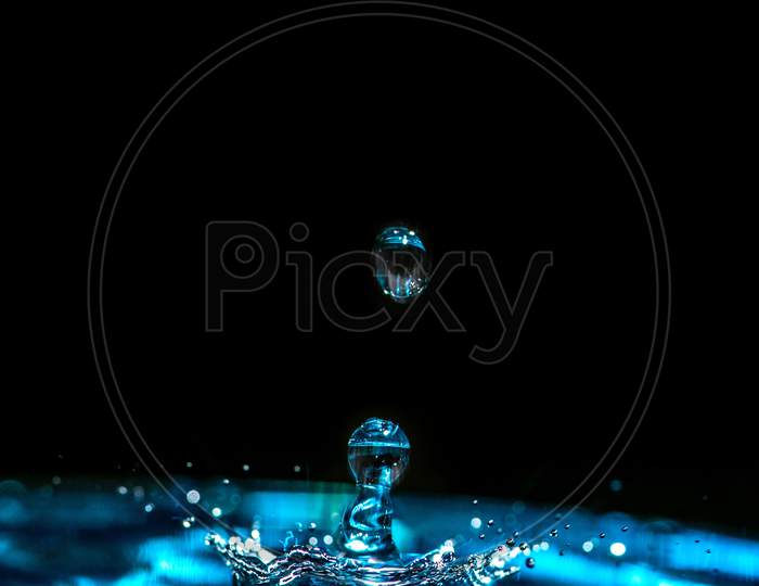 Aqua round water drop photography in dark black background