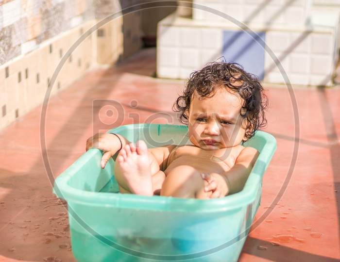 Grandmother Showering a Baby In a Tub