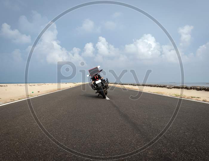 Motorcycle Isolated Standing On Tar Road In Sea Shore Background