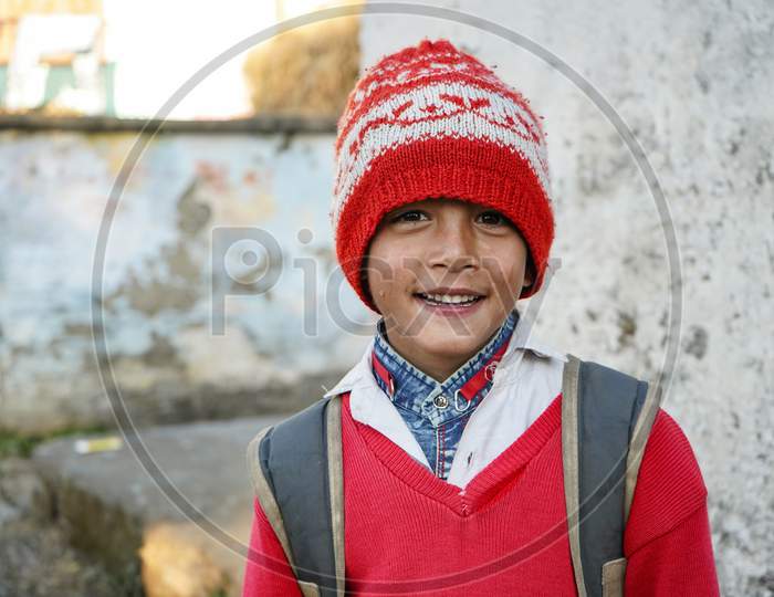 Almora, Uttrakhand / India- May 25 2020 : Portrait Of A Young Kid Smiling Wearing Red Cap And Red Uniform Of School