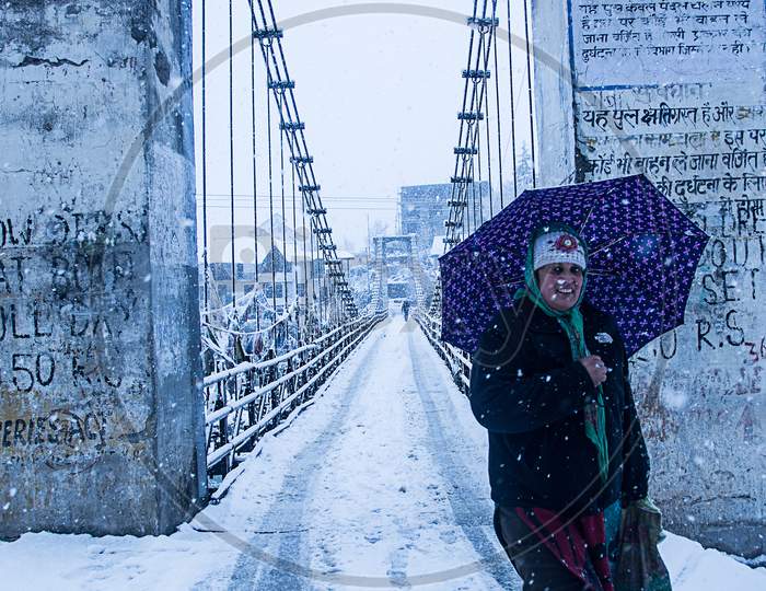 Manali, India - Jan 22, 2019: Heavy Winter Snow Fall, A Person Walking Alone With Umbrella On The Bridge, Wide Angle Shot - Image