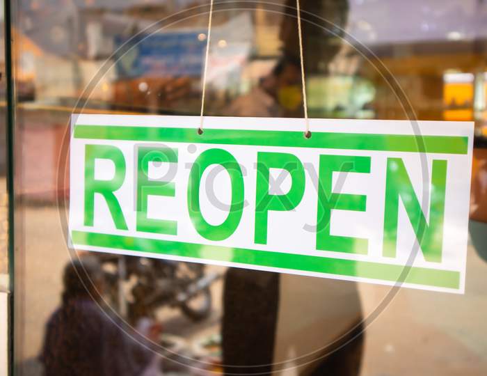 Reopen Signage Board In Front Of Businesses Or Store Door After Covid-19 Or Coronavirus Crisis- Concept Of Back To Business After Lockdown.