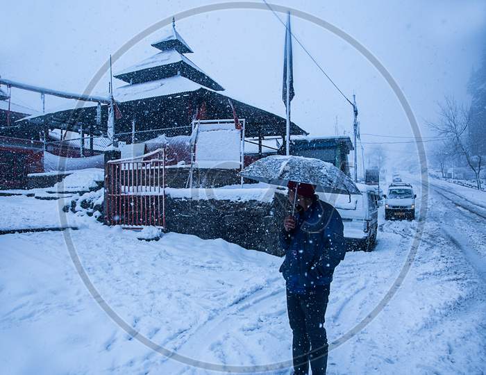 Manali, India - Jan 22, 2019: Old Wooden Temple Covered With Snow,, Man With Umbrella Winter Snowfall In Himalaya - Image