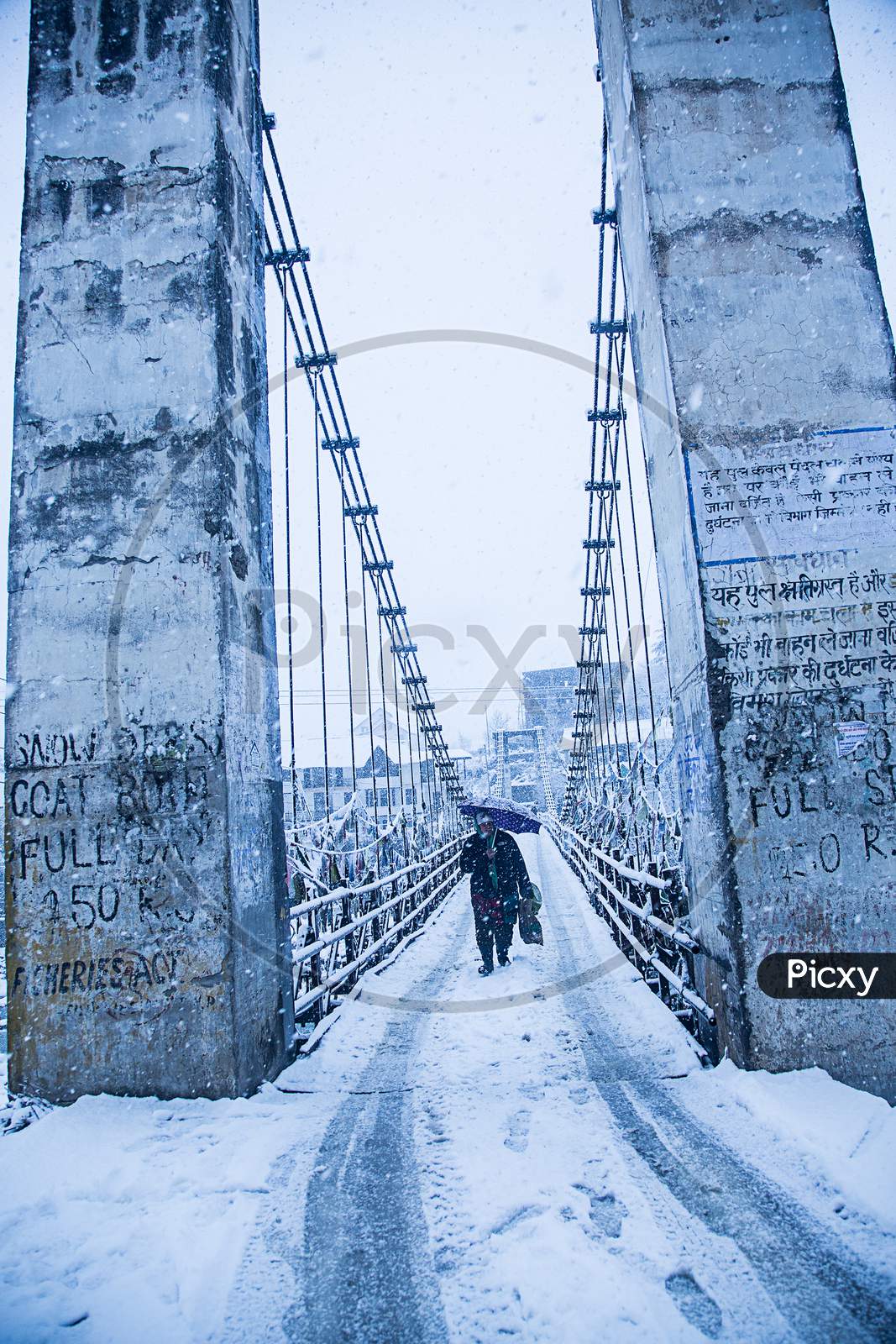 Manali, India - Jan 22, 2019: Heavy Winter Snow Fall, A Person Walking Alone With Black Umbrella On The Bridge, Wide Angle Shot - Image