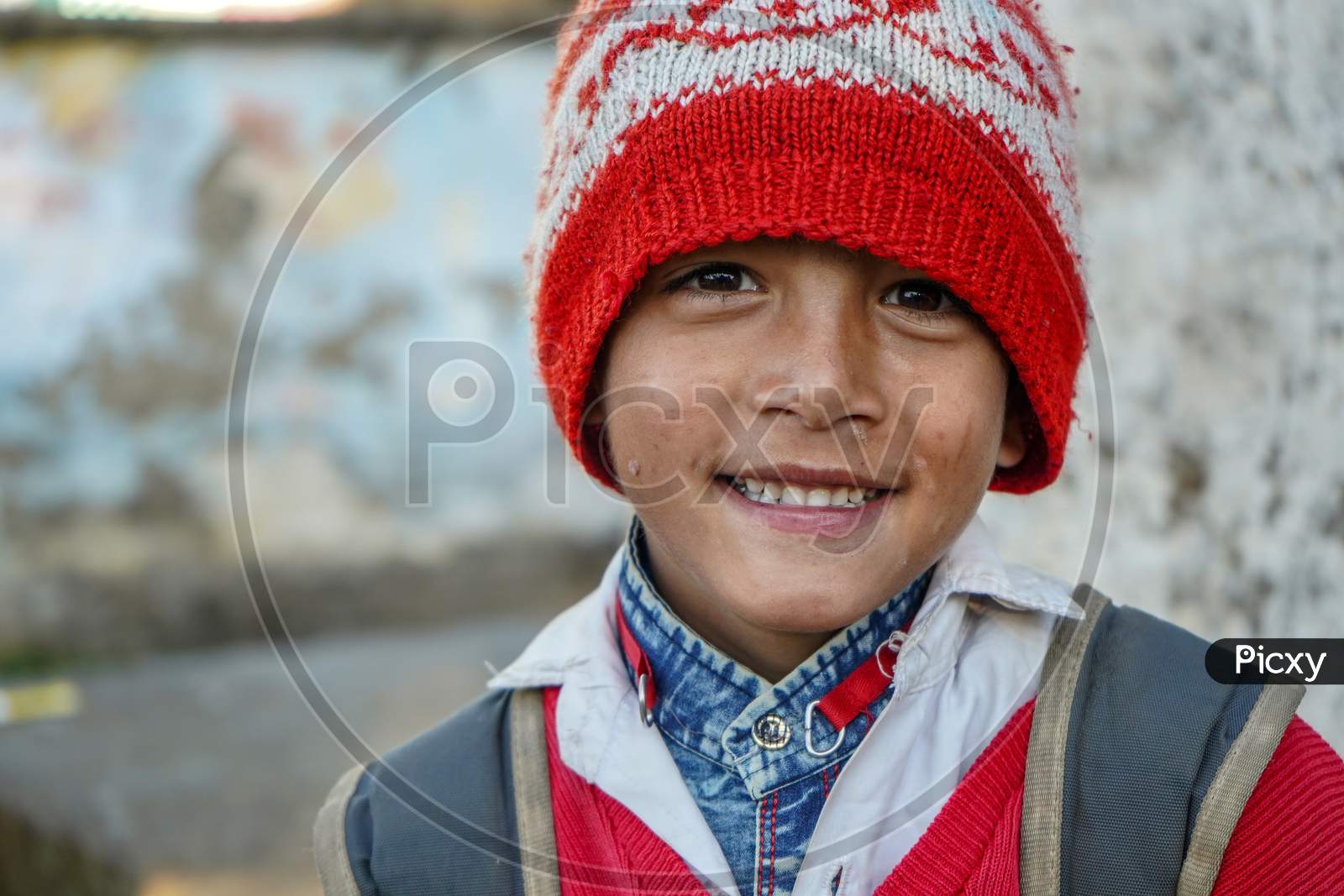 Almora, Uttrakhand / India- May 25 2020 : Portrait Of A Young Kid Smiling Wearing Red Cap And Red Uniform Of School
