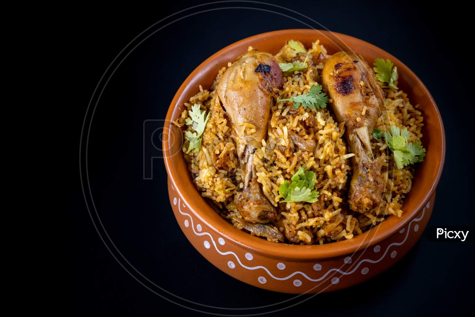 Indian Chicken Biryani Served In A Earthen Bowl With  Over Black  Background.
