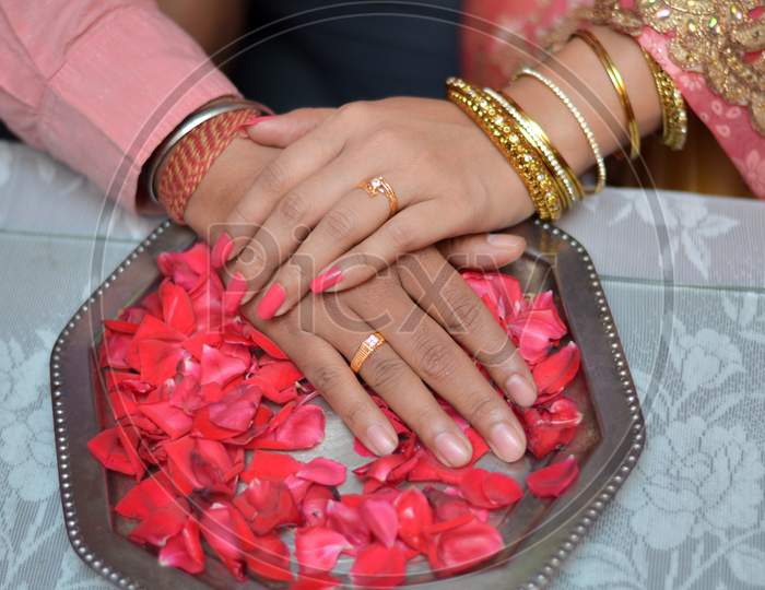 Bride and groom exchange engagement ring in Indian Hindu wedding.