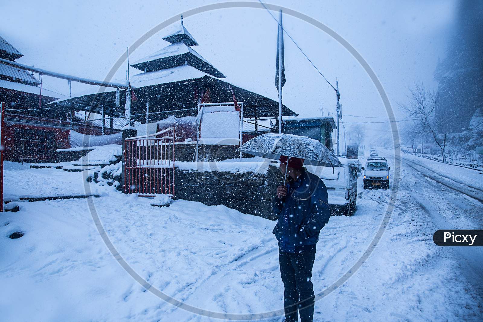 Manali, India - Jan 22, 2019: Old Wooden Temple Covered With Snow,, Man With Umbrella Winter Snowfall In Himalaya - Image