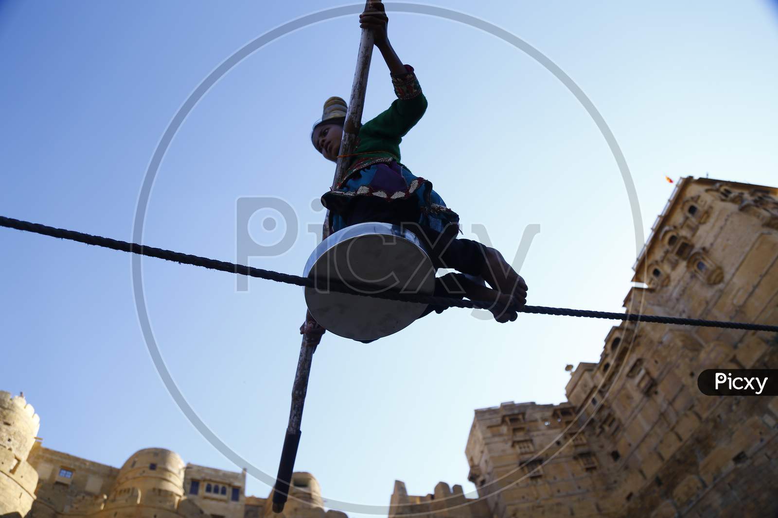 An unidentified Indian girl performs street acrobatics by walking the rope during the Desert Festival in Jaisalmer, Rajasthan, India.