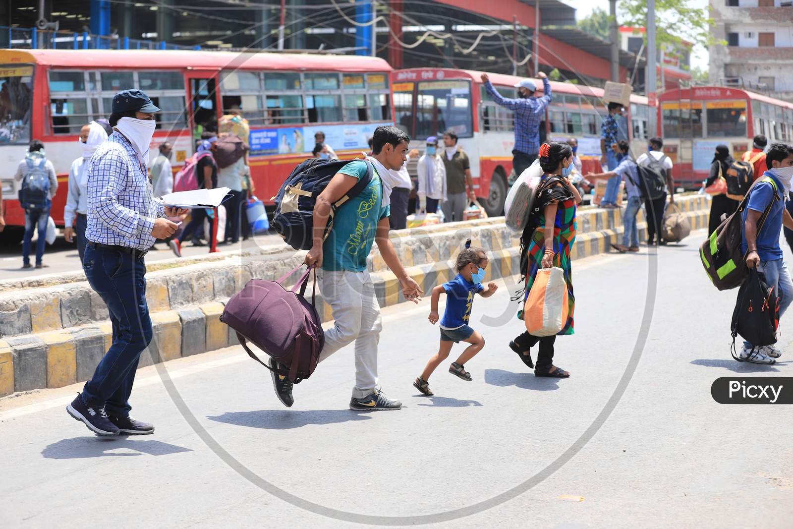 Migrants Run To Board Buses To Reach Their Native Places After Arriving by A Special Train During Extended Nationwide Lockdown Amidst Coronavirus Or COVID-19 Pandemic In Prayagraj, May 25, 2020.