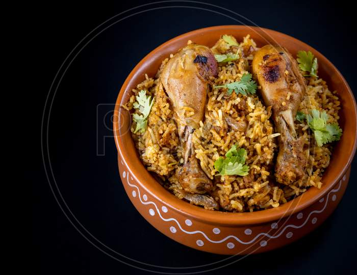 Indian Chicken Biryani Served In A Earthen Bowl With  Over Black  Background.