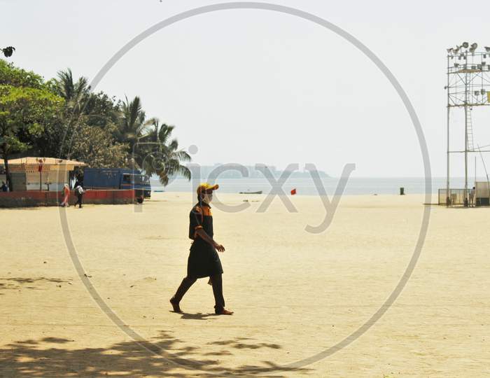 A man wearing a protective mask walks on deserted Girgaon Chowpatty after the Maharashtra state government banned public gatherings to avoid the spreading of the coronavirus, in Mumbai, India on March 18, 2020.