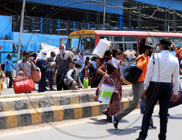Migrants Run To Board Buses To Reach Their Native Places After Arriving by A Special Train During Extended Nationwide Lockdown Amidst Coronavirus Or COVID-19 Pandemic In Prayagraj, May 25, 2020.