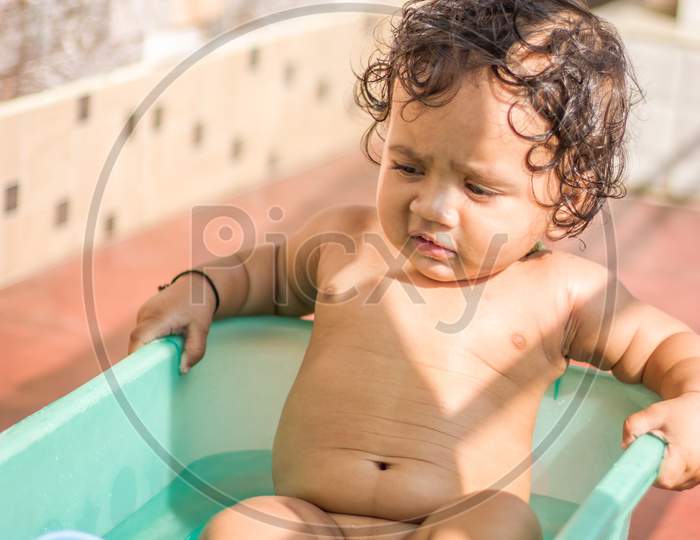Grandmother Showering a Baby In a Tub