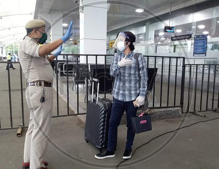 Policeman checks a passenger As She Arrives At Lokpriya Gopinath Bordoloi International Airport, Following The Resumption Of Domestic Flights, In Guwahati, Monday, May 25, 2020.