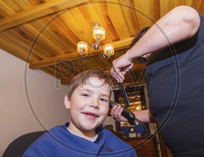 Boy Is Having A Haircut At Home By Grandmother