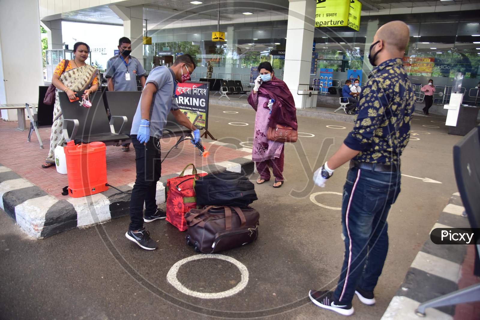 A Worker Sanitizing A Bag Of Passenger  Outside  Lokpriya Gopinath Bordoloi International Airport, Following The Resumption Of Domestic Flights, In Guwahati On May 26,2020.