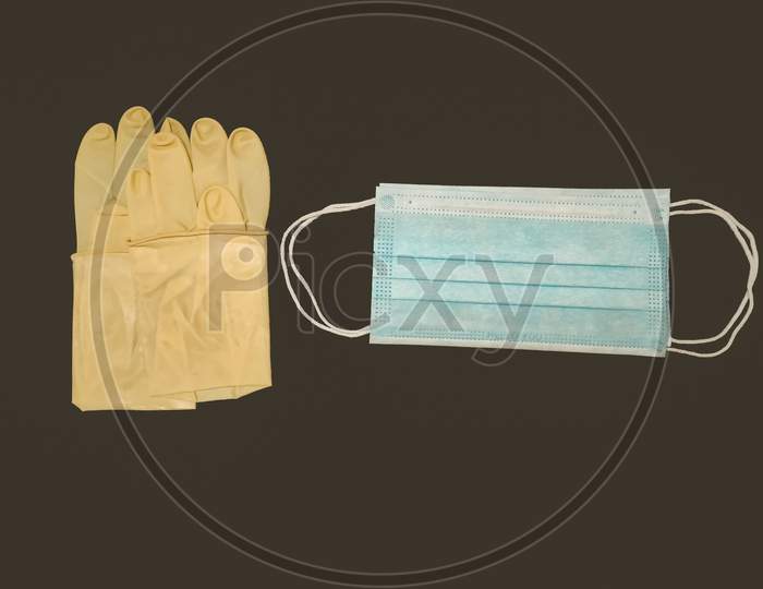 Disposable Protective Surgical Mask And Gloves Isolate In Black Background.