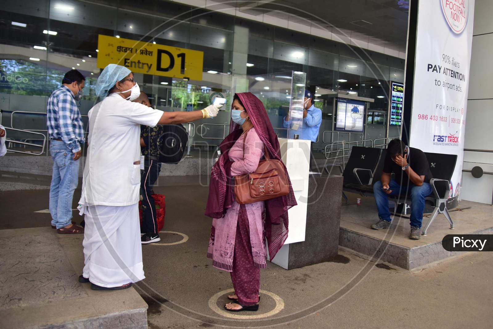 A Passenger Gets Thermal Screening As She Arrives At Lokpriya Gopinath Bordoloi International Airport, Following The Resumption Of Domestic Flights, In Guwahati On May 26,2020.