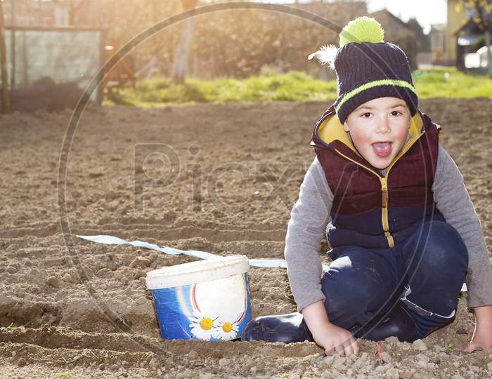 The Young Boy Is Happy To Plant A Garden