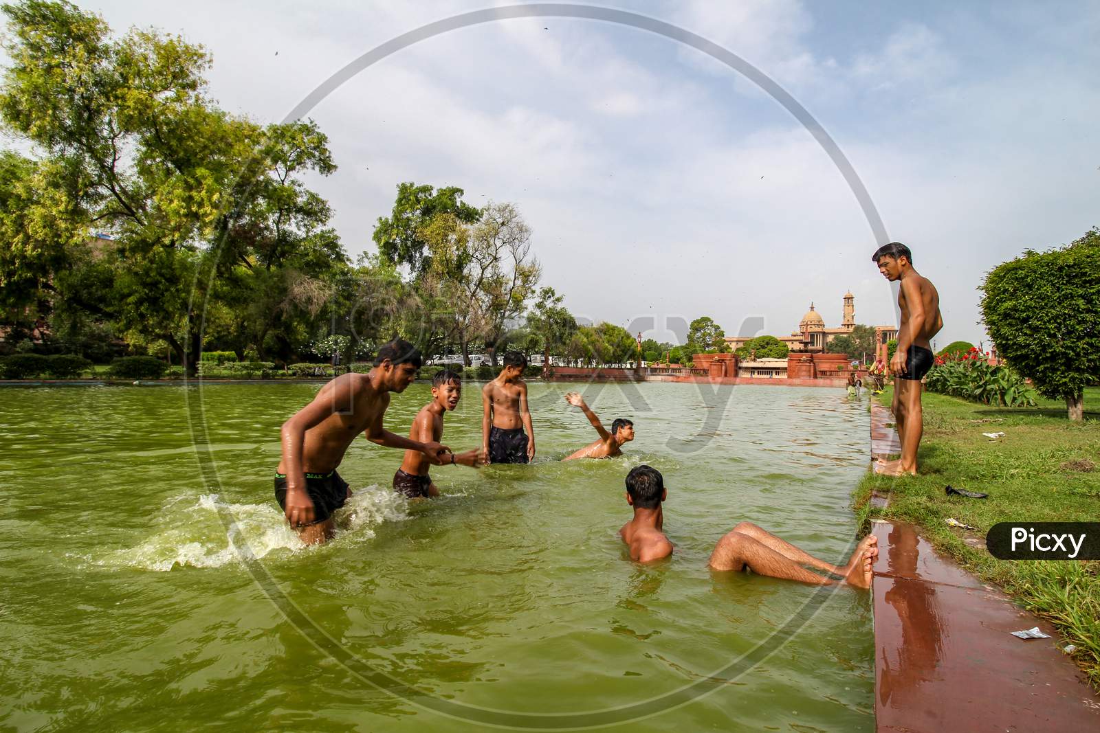 Delhi, New Delhi, India - May 26 2020: Happy Asian Kids Playing In A Lake Near India Gate In The Hot Summer. Cheerful And Carefree Children.