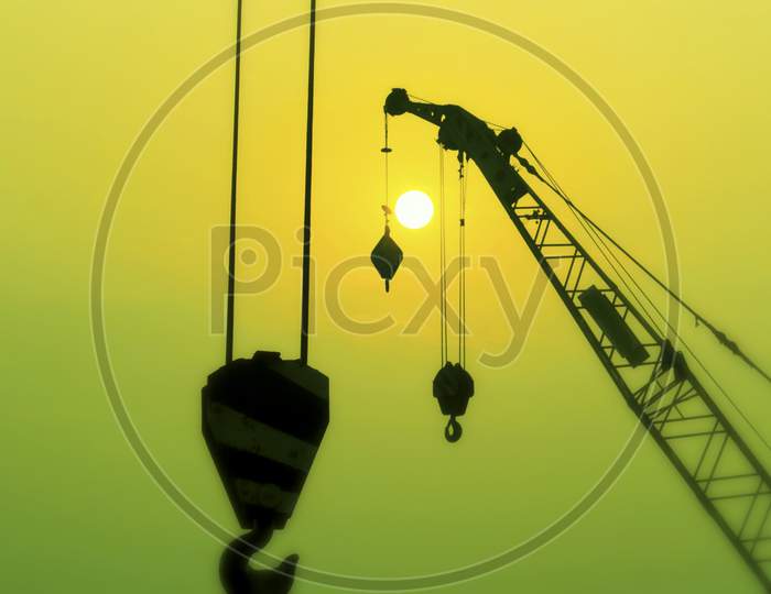 Silhouette Of Construction Site Crane In Sunset