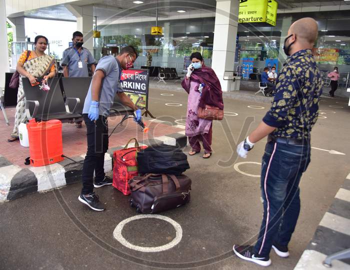 A Worker Sanitizing A Bag Of Passenger  Outside  Lokpriya Gopinath Bordoloi International Airport, Following The Resumption Of Domestic Flights, In Guwahati On May 26,2020.