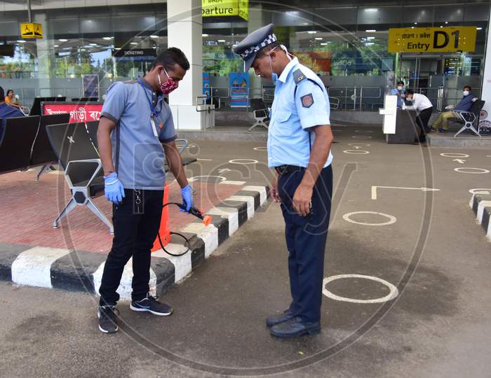 A Worker Sanitizing A Traffic Police Shoes At Lokpriya Gopinath Bordoloi International Airport,, In Guwahati On May 26,2020
