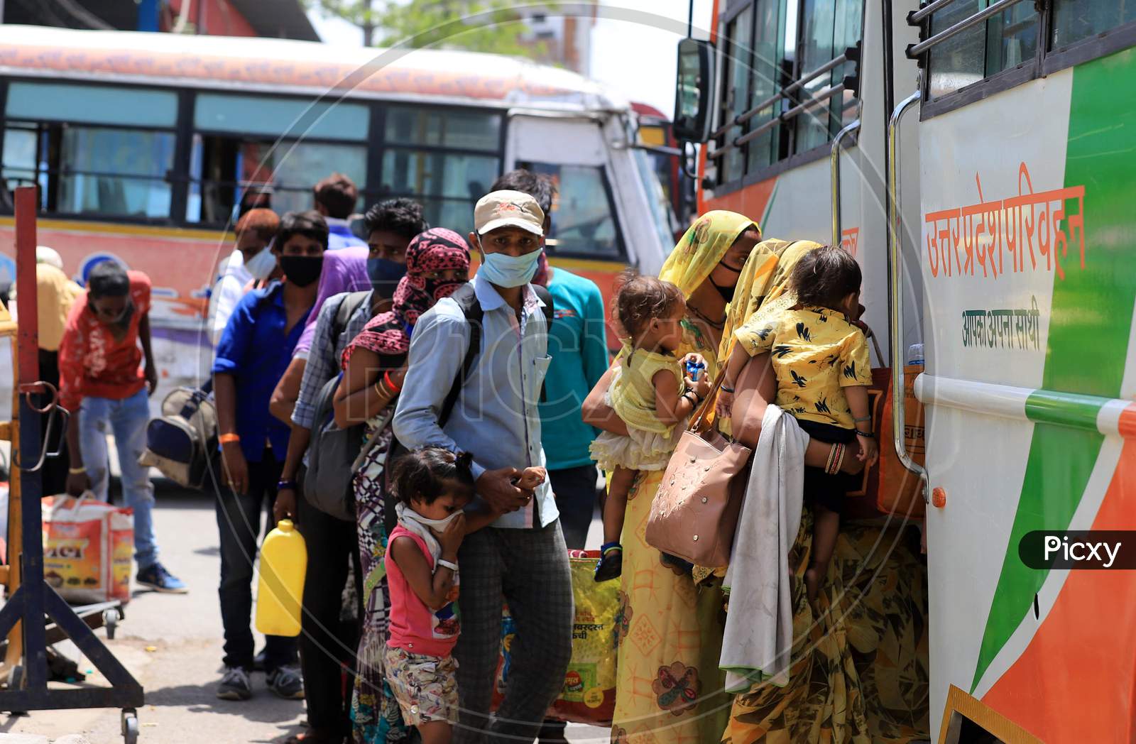Migrants With Children Board Buses To Reach Their Native Places After Arriving From A Special Train  In Prayagraj, May 26, 2020.