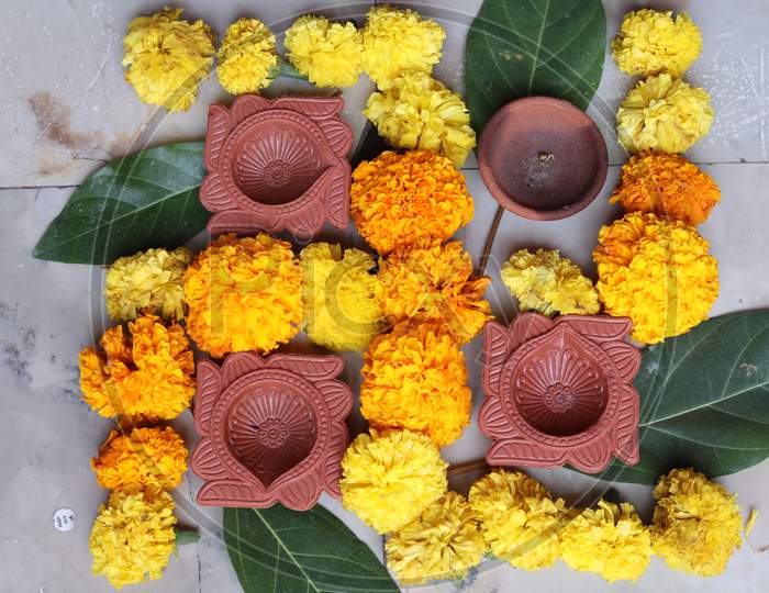 Swastika made using Marigold flowers for Ugadi with Clay Oil Lamp