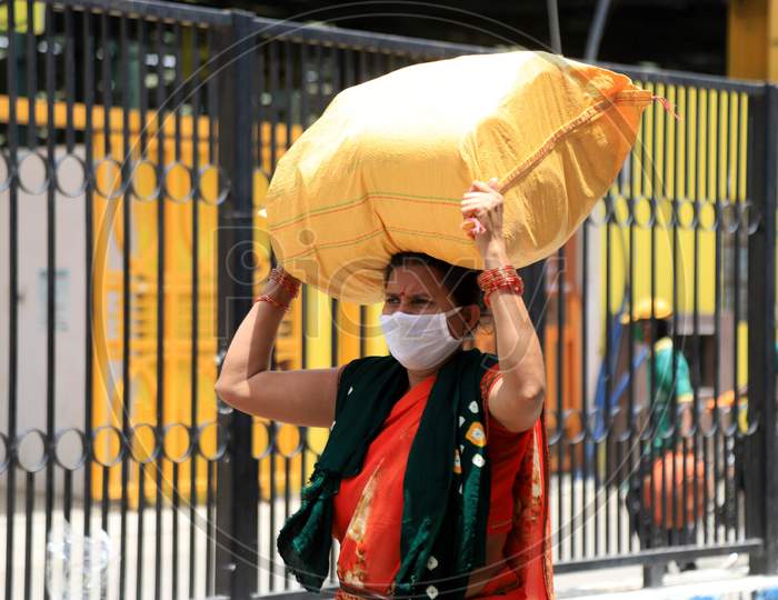 A Migrant Woman Carries Luggage On Her Head As She Walks To Reach A Bus To Take Her To Her Home During extended Nationwide Lockdown amidst  Coronavirus or COVID-19 Pandemic  In Prayagraj, May 27, 2020.