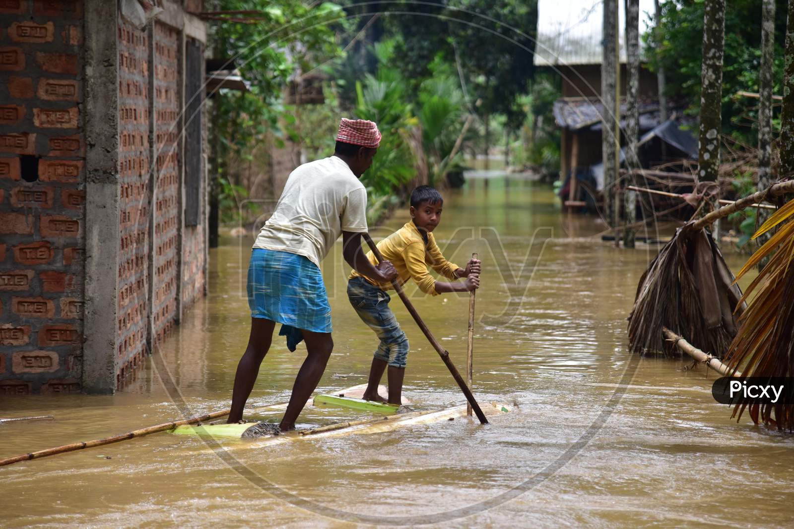 A Villager  Rows A Makeshift Raft Past Submerged Houses At A Flood-Affected   Bakulguri Village Near Kampur In Nagaon District Of Assam On May 27,2020