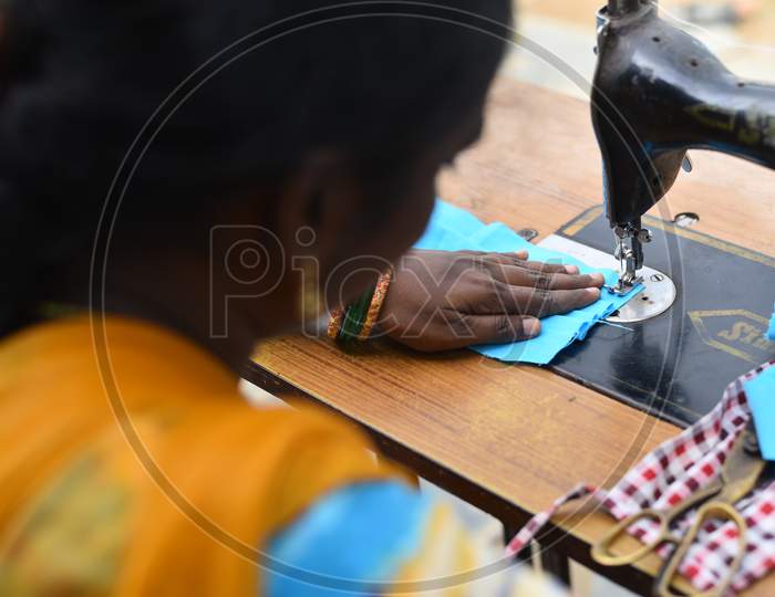 A woman SHG ( Self Help Groups) worker stitches face masks that are to be distributed among the poor in rural areas during an extended nationwide lockdown amid fears of coronavirus, May 7, 2020.