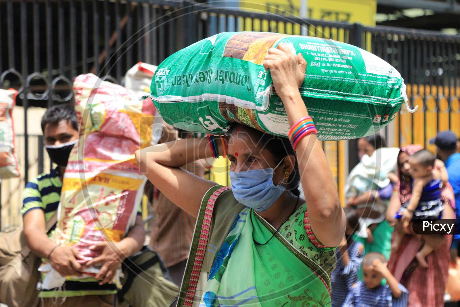 A Migrant Woman Carries Luggage On Her Head As She Walks To Reach A Bus  During extended Nationwide Lockdown amidst  Coronavirus or COVID-19 Pandemic  In Prayagraj, May 27, 2020.